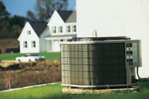 Central air conditioner with home in background